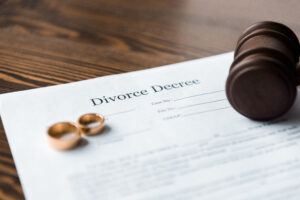 close-up view of a Michigan divorce decree, wedding rings and wooden hammer
