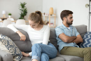 Unhappy married couple sitting on couch during a mediation session in Michigan.