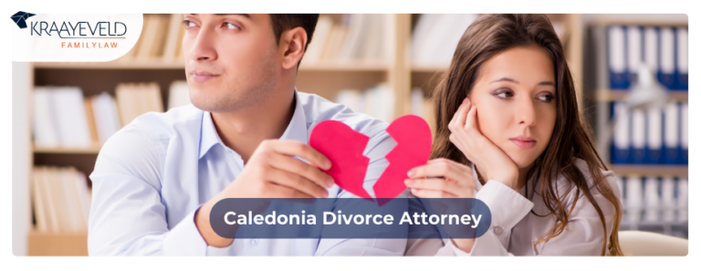Couple representing the concept of divorce by ripping a paper heart apart