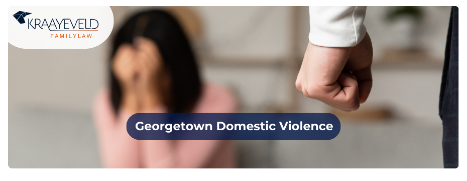 Close-up of the clenched fist of a man and a crying woman sitting behind suggesting domestic violence